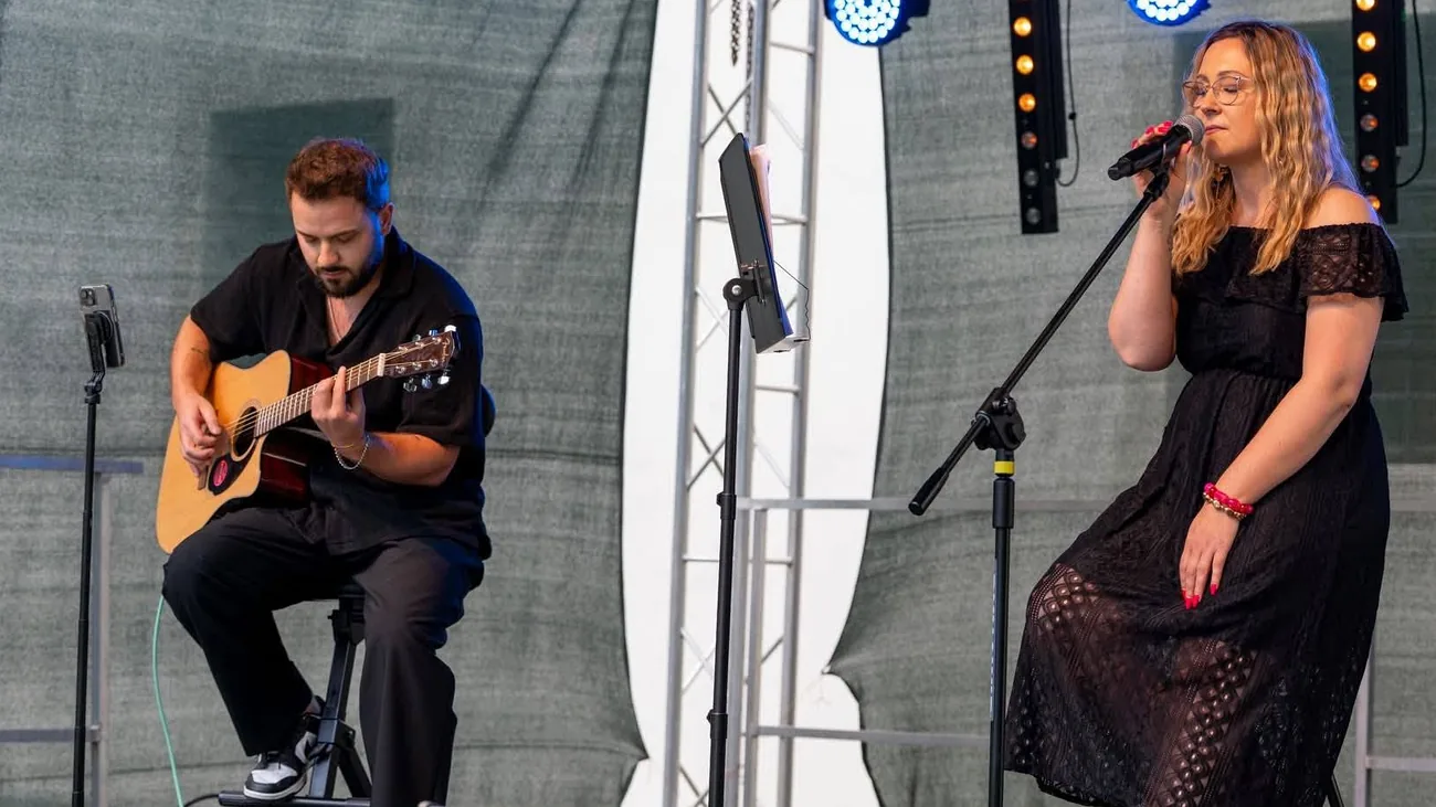 Gabriela Krzeszowiak przy mikrofonie i Maciej Mięso z gitarą podczas koncertu na Scenie Parkowej