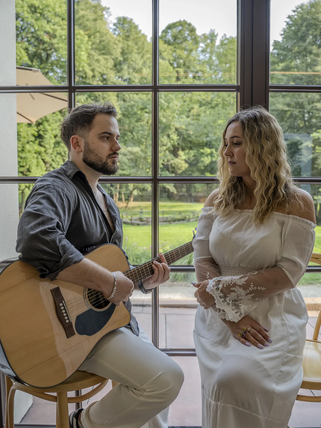 Maciej gra na gitarze, Gabriela słucha - próba przy oknie oranżerii